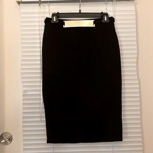 Black fitted skirt with gold platted buckle. Stretchy and hits under knee